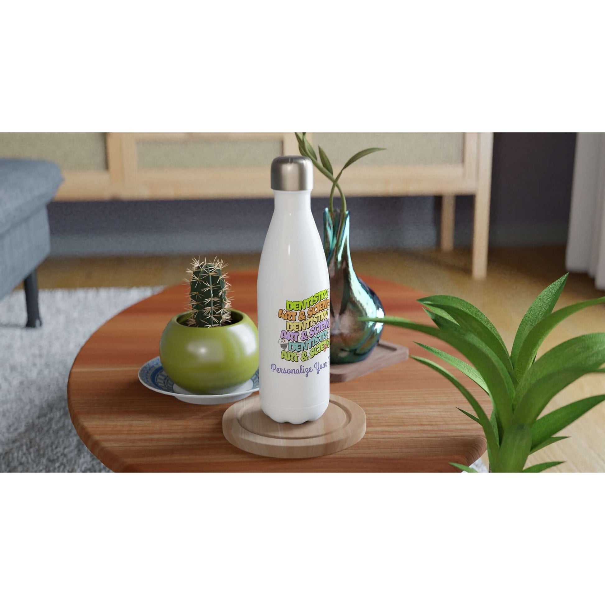 Art & Science Dentistry personalized 17oz stainless steel water bottle on a wooden table with plants and decor.
