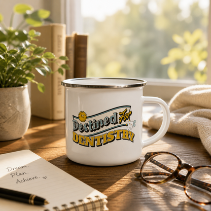 White mug with 'Destined for Dentistry' text on a wooden table with books, plant, and glasses.