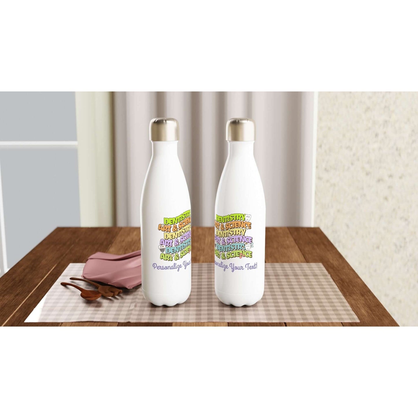 Art & Science Dentistry personalized 17oz stainless steel water bottle on a table with cutlery and a pink napkin.