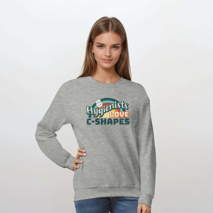 Woman wearing a gray sweatshirt featuring "Hygienists LOVE C-Shapes" graphic, perfect for dental professionals.
