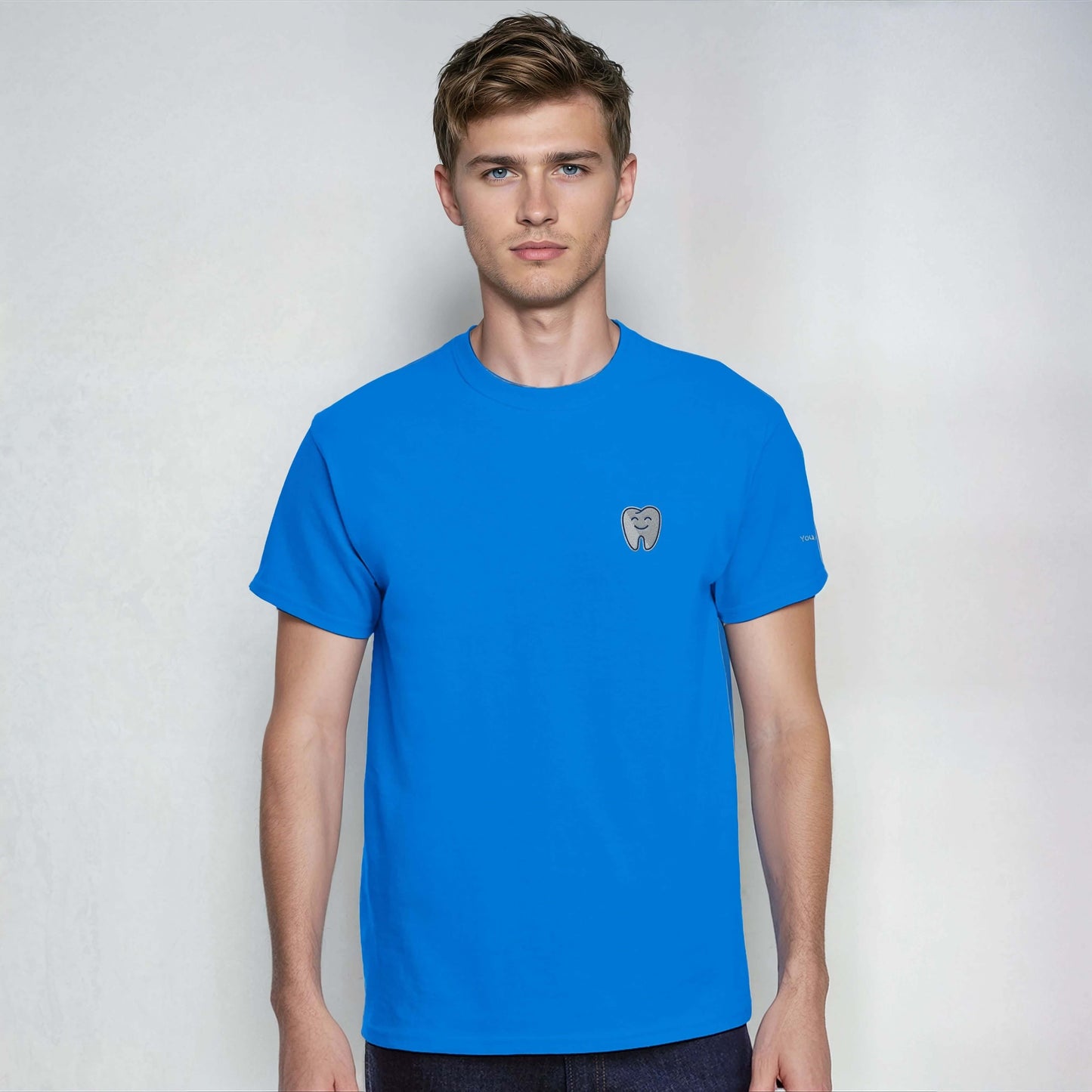 Person wearing a blue Personalized Heavyweight Unisex Crewneck T-Shirt with Smiling Tooth Embroidery.