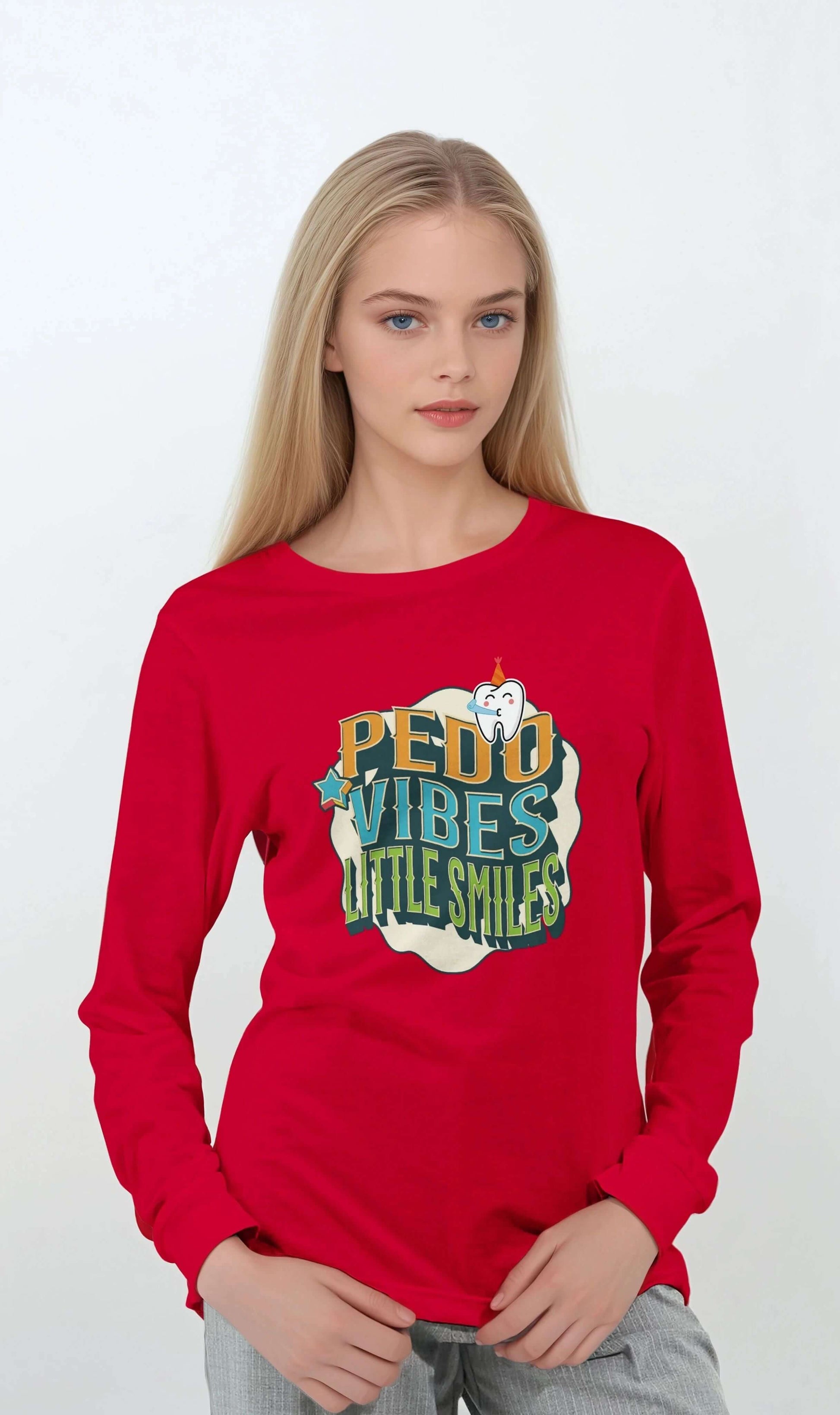 Model wearing a red personalized long sleeve T-shirt with 'PEDO VIBES' and 'Little Smiles' design for pediatric dentistry.